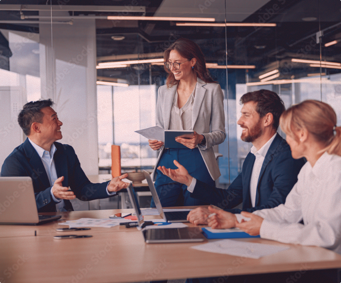 Homepage 7 digital marketers working together at a table with laptop, mouse, and hard drive.